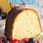Slice of pound cake on a small plate with berries and whipped cream.