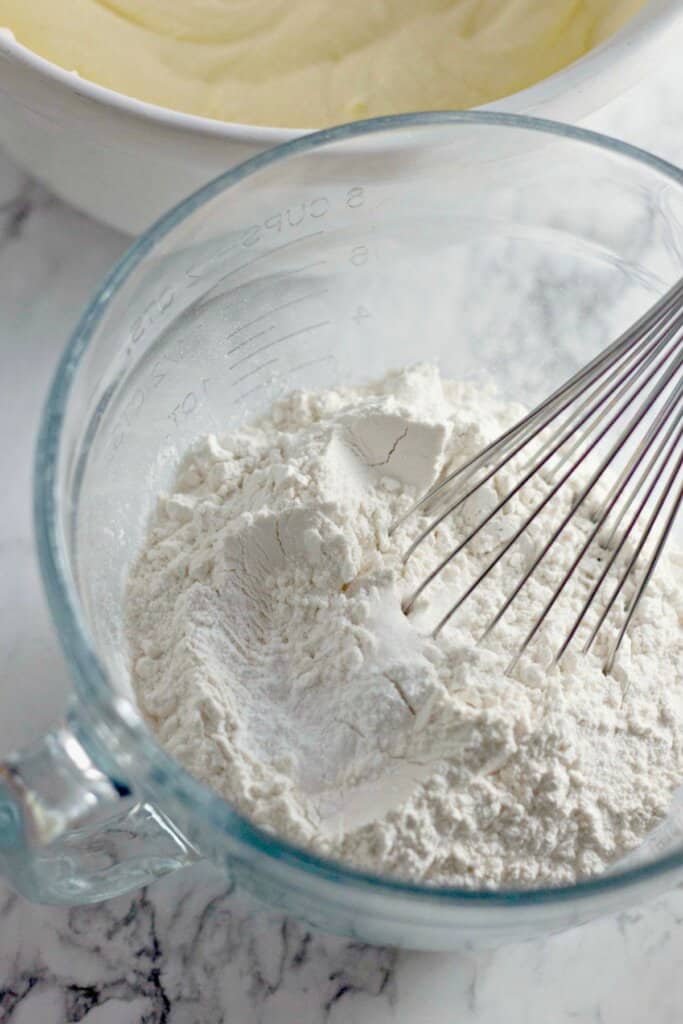 Dry ingredients being mixed in a glass mixing bowl.