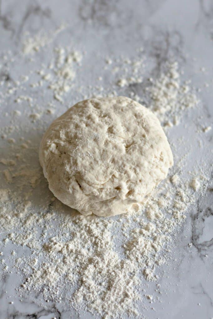 Dough being kneaded on a counter.