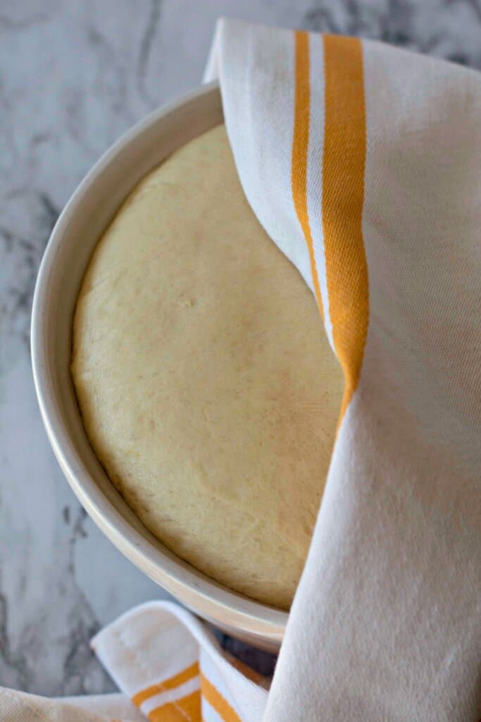 Dough rising in a towel covered bowl.