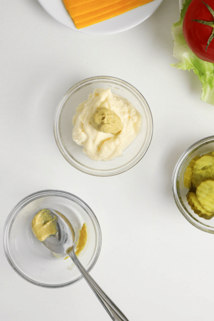 Mixing the mayo and mustard together with a spoon.