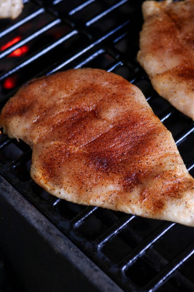 Cooking the seasoned chicken on the grill.