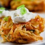 Onion fritter on a small white plate.