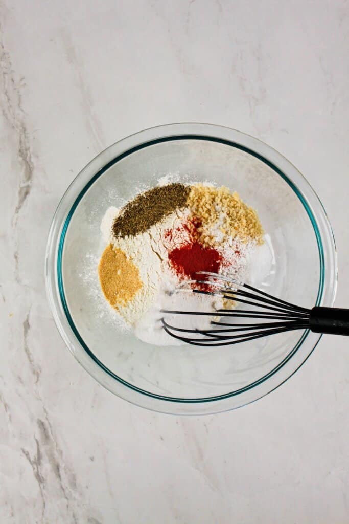 Dry ingredients being mixed in a large glass bowl.