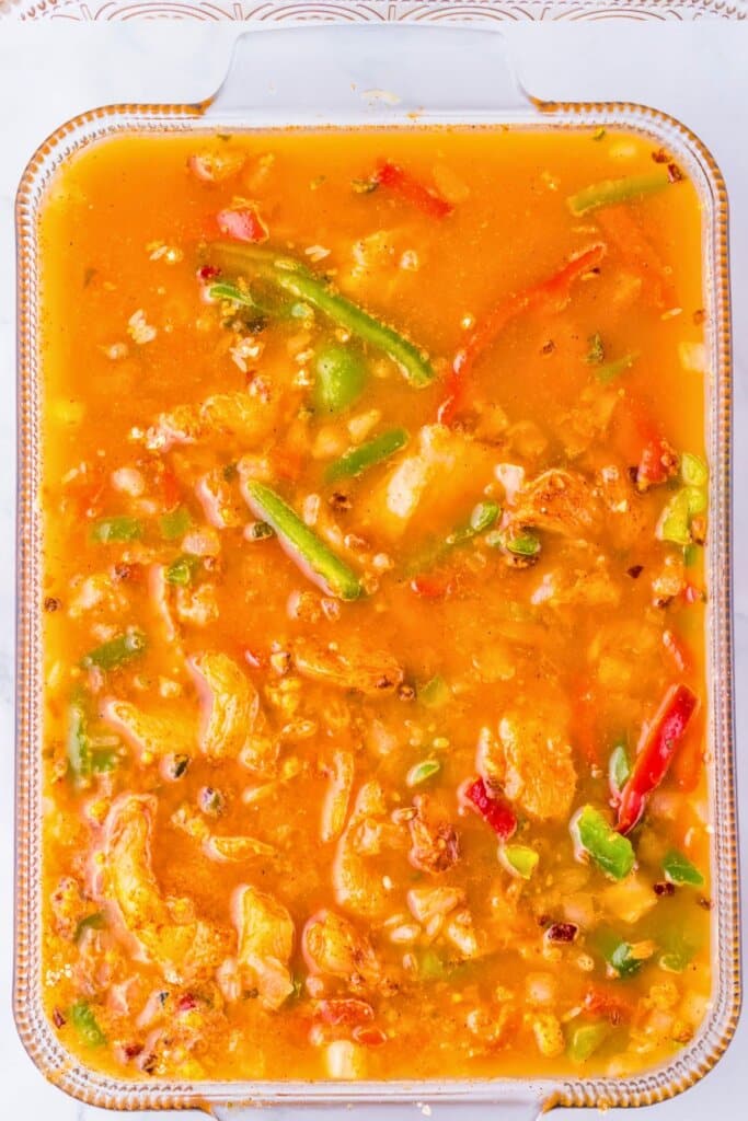 Broth and veggies in a glass baking dish.