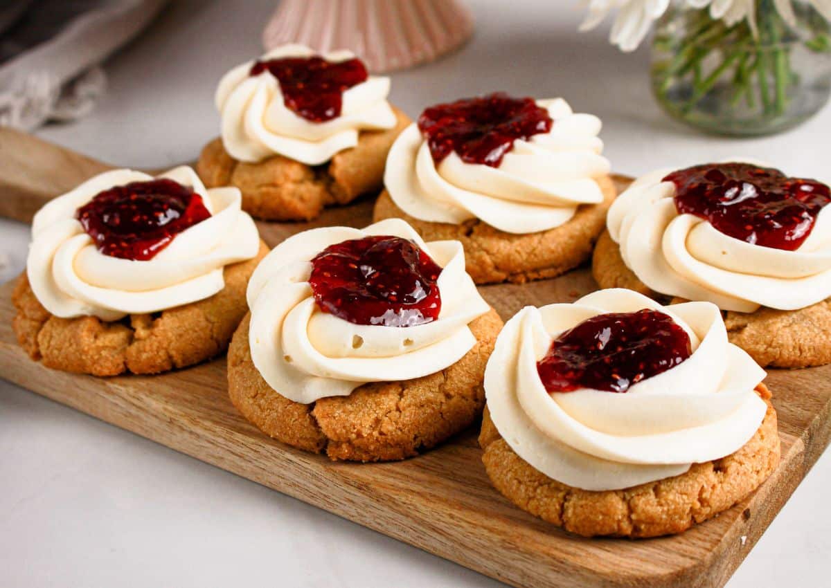 6 Raspberry cheesecake cookies on a wooden cutting board.