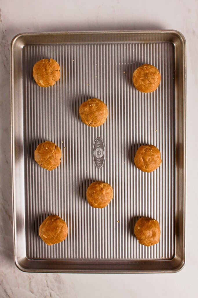 Dough balls on a metal cookie sheet.