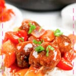 Small plate of rice topped with sweet and sour meatballs.