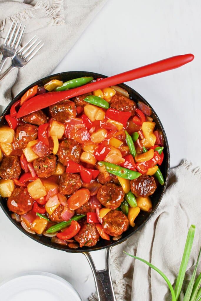 Skillet full of meatballs and veggies.